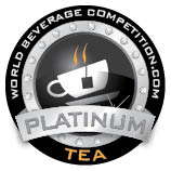 Circular Award Badge for World Beverage Competition Featuring a Steaming Teacup and a Platinum Tea Ribbon Indicating a Platinum Tea Prize